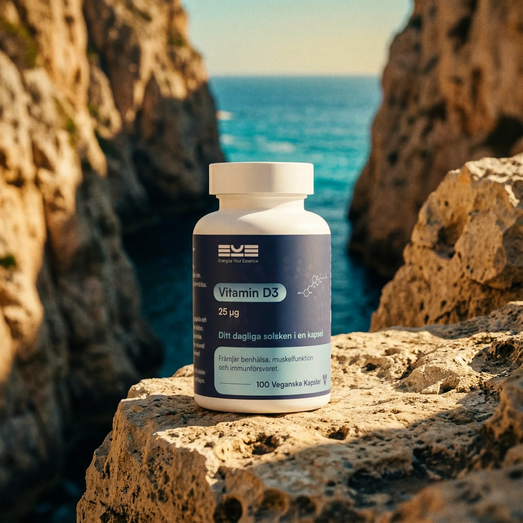 Vitamin D3 25 µg från Energize Your Essence placerad på klippa vid havet, med turkost vatten och dramatiska klippformationer i bakgrunden