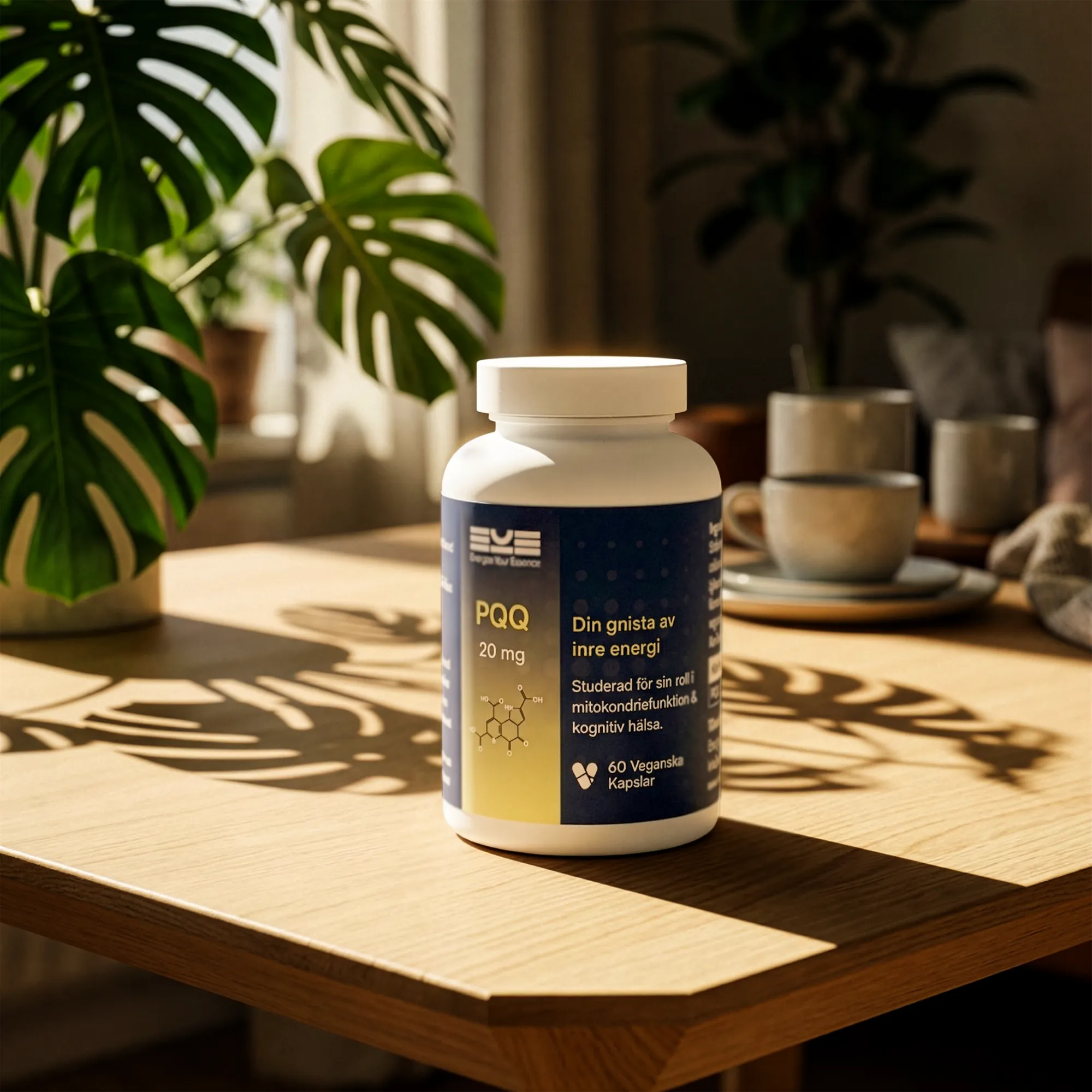 PQQ 20 mg kosttillskott från Energize Your Essence placerad på ett träbord i varmt solljus, med skuggor från gröna växter och en lugn hemmiljö i bakgrunden