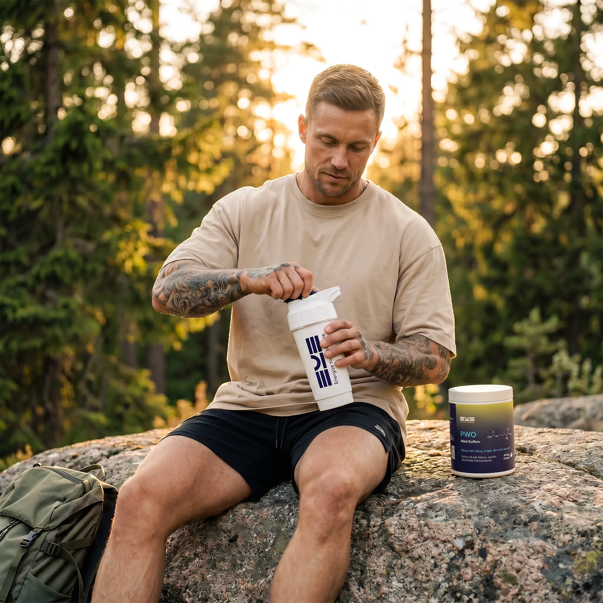 Man blandar PWO med koffein från Energize Your Essence i shaker utomhus på klippa i skogsmiljö, med ryggsäck och burk bredvid i varmt kvällsljus